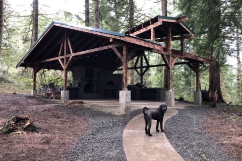 Timber frame pavilion with outdoor kitchen and fireplace.